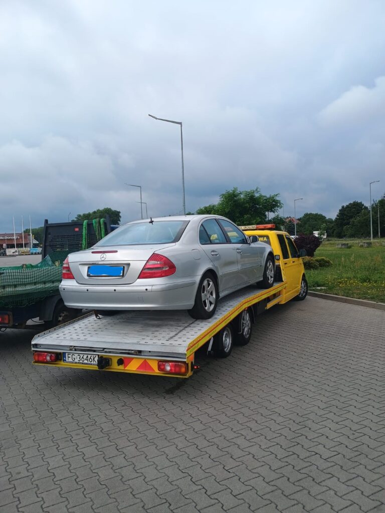 Laweta Polska podczas transportu pojazdu po awarii na drodze, zapewniając bezpieczne i szybkie przewiezienie samochodu do wybranego miejsca.